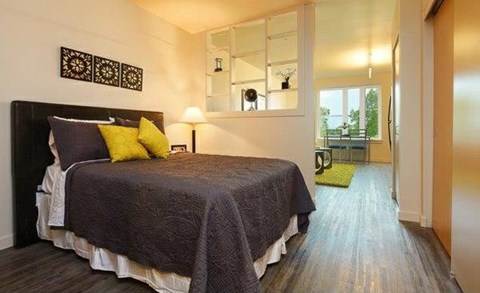 A bedroom with a bed and a mirror on the wall.